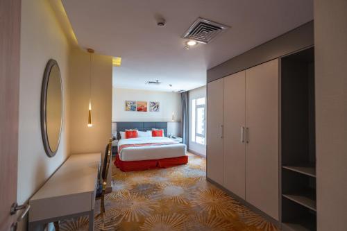 a bedroom with a bed and a large closet at Wahaj Boulevard Hotel Apartmentوهج بوليفارد للشقق الفندقية in Kuwait