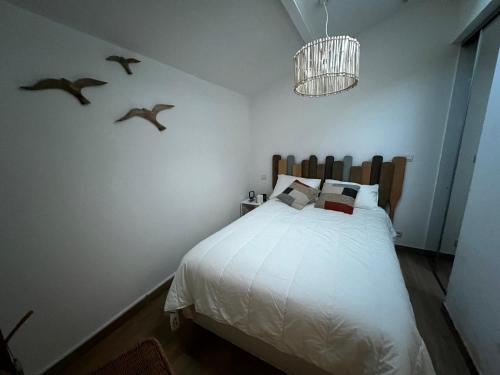 - une chambre avec un lit avec des oiseaux sur le mur dans l'établissement Pure Marina - Résidence Marina Plage, à Leucate