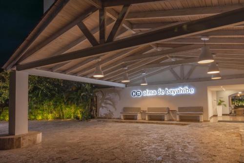 einem Pavillon mit Bänken und einem Schild an der Wand in der Unterkunft HM Alma de Bayahibe - Adults Only in Bayahibe