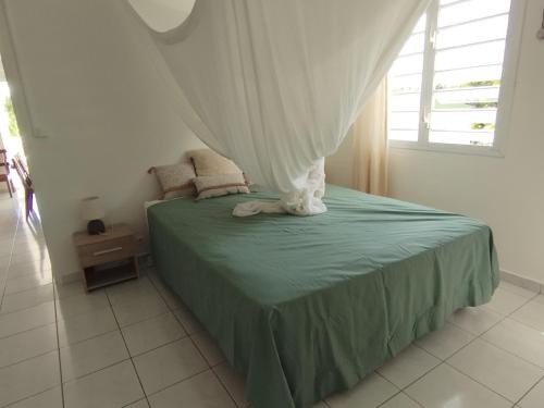 大博格Bas de villa vue mer avec deux chambres的一间卧室配有一张带天蓬的床