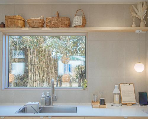 a kitchen counter with a sink and a window at Aewol Gilro in Jeju
