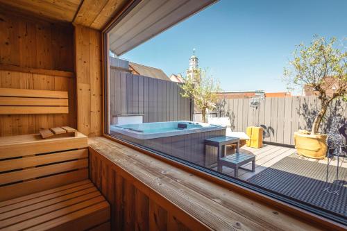 a jacuzzi tub sitting on a deck with a window at Hotel Residenz in Ravensburg