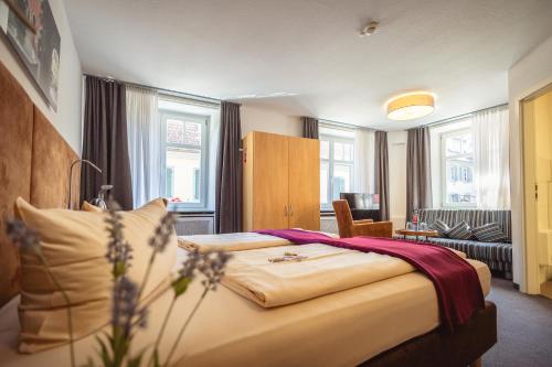 a bedroom with a large bed and a living room at Hotel Residenz in Ravensburg