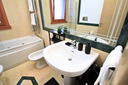 a bathroom with a sink and a toilet and a mirror at Ecosuite your design Escape in Rome