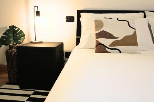 羅馬的住宿－Ecosuite your design Escape，一间卧室,配有一张带植物和灯的床