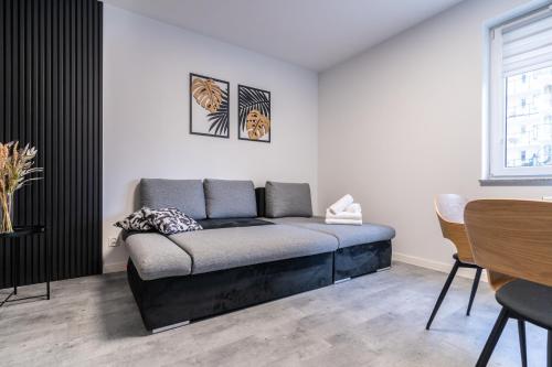 a bed in a room with a table and a window at Park Śląski Modern Studio in Katowice