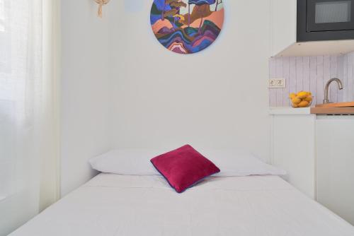 マラガにあるSuite Málaga Centerの白いベッド(赤い枕付)
