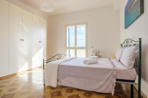 uma cama branca num quarto com uma janela em Maestrale Sea View Living Quarters em Porto Cesareo