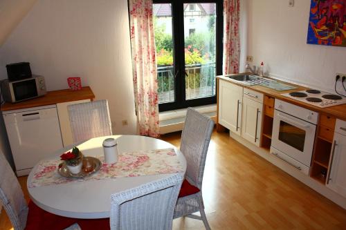 una cocina con una mesa y sillas blancas y una ventana en Ferienwohnung "Am Münstertor", en Telgte