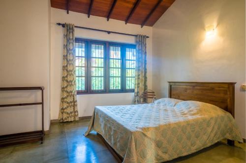 a bedroom with a bed and a large window at The Fields Malabe in Malabe