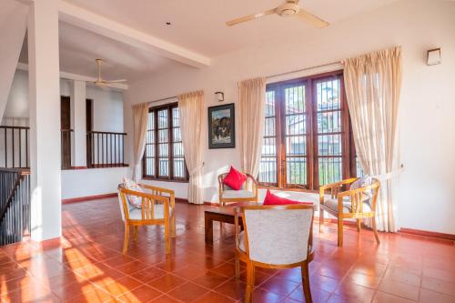 a living room with tables and chairs and windows at The Fields Malabe in Malabe