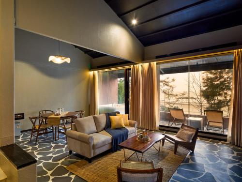 a living room with a couch and a table at Red Thread Morjim in Morjim