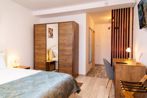 a hotel room with a bed and a desk and a chair at Apartament ALESSIO in Drobeta-Turnu Severin