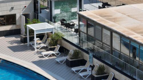 a balcony with chairs and a table and a pool at YM Resort in Yanbu