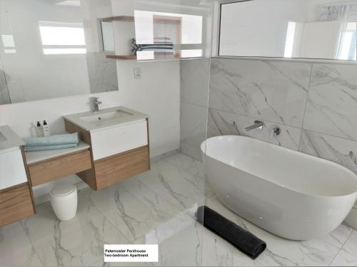 a white bathroom with a tub and a sink at Paternoster Penthouse - Solar in Paternoster