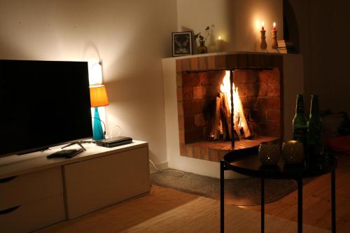 a living room with a fireplace with a tv and a table at Bograngen LGH D in Brograngen