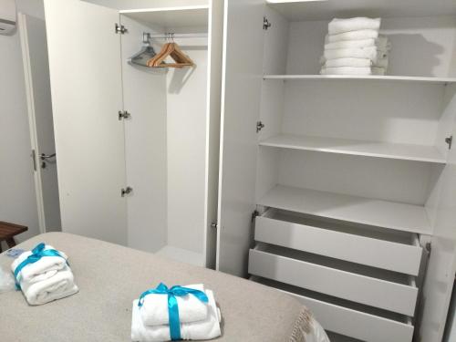 - un placard avec des serviettes sur un lit dans l'établissement Cais das Pedras Pátio Apartment, à Porto