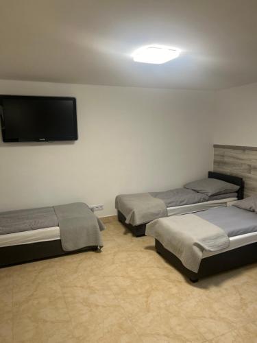 una camera con tre letti e una TV a schermo piatto di Hostel 24 Miejsca Parkingowe Noclegi Pracownicze. a Gorzów Wielkopolski