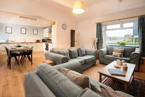 a living room with a couch and a table at Thornton Farm Cottages in Berwick-Upon-Tweed