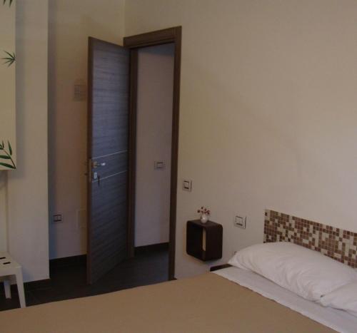 - une chambre avec un lit et une porte avec une télévision dans l'établissement B&B Verziere, à Jesi