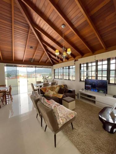 a living room with a couch and a tv at Apartamento Cobertura Ingleses Gr in Florianópolis