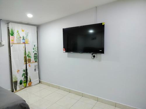 a room with a flat screen tv on a white wall at The Big Family Homestay in Alor Setar