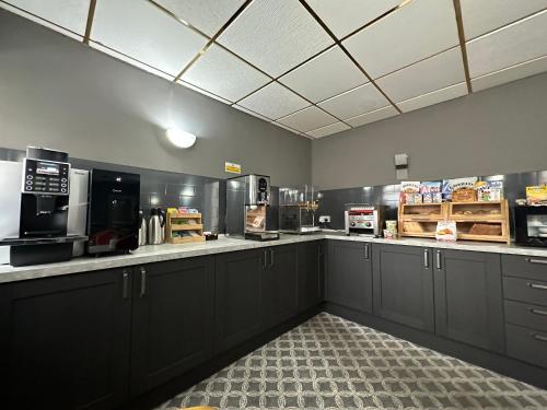 a kitchen with black cabinets and a counter top at The Villa Hotel in Blackpool