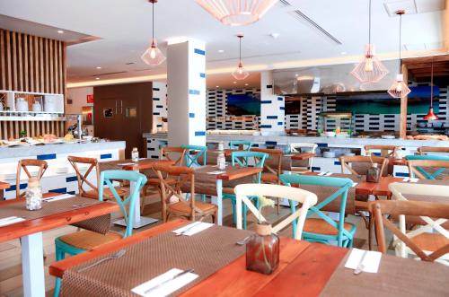 a restaurant with wooden tables and chairs and a bar at FERGUS Cactus Garden in Playa Jandia