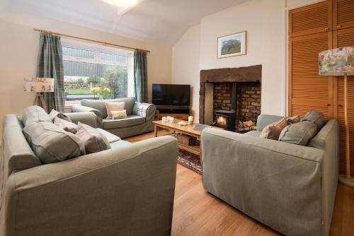 a living room with two couches and a fireplace at Thornton Farm Cottages in Berwick-Upon-Tweed
