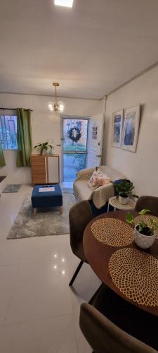 uma sala de estar com uma mesa e um sofá em Cassie Homestay - Yuna Door 2 - Furnished Home in Butuan em Butuan