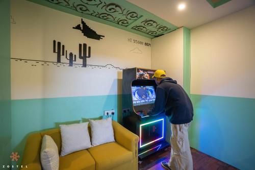 a man is playing a video game on a television at Zostel Mussoorie (Mall Road) in Mussoorie