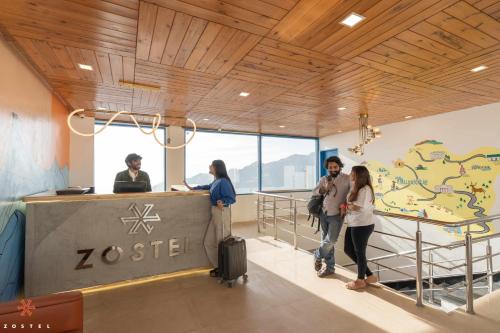 a group of people standing at a zeus sign in a building at Zostel Mussoorie (Mall Road) in Mussoorie