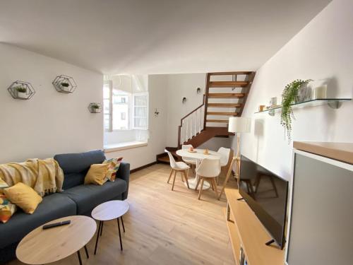 ein Wohnzimmer mit einem blauen Sofa und einem Tisch in der Unterkunft Edificio El Moderno Puerta del Sol in Vigo