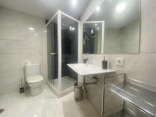 a white bathroom with a sink and a toilet at Edificio El Moderno Puerta del Sol in Vigo