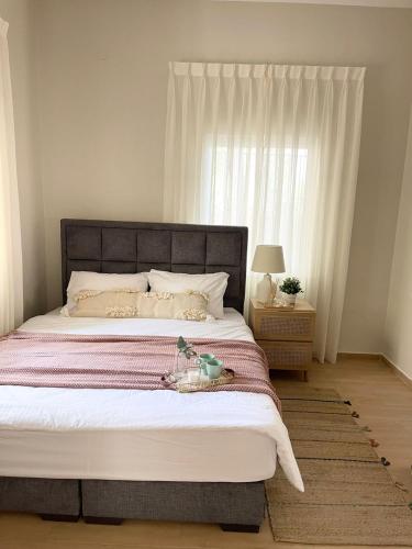 um quarto com uma cama grande e uma janela em شقة مريحةمع إطلالة ،أثاث بوهيمي em Amã
