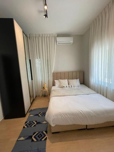 um quarto com uma cama grande e um tapete azul em شقة مريحةمع إطلالة ،أثاث بوهيمي em Amã