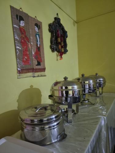 two pots and pans on a counter in a kitchen at Shivaji Inn Kaziranga in Kāziranga