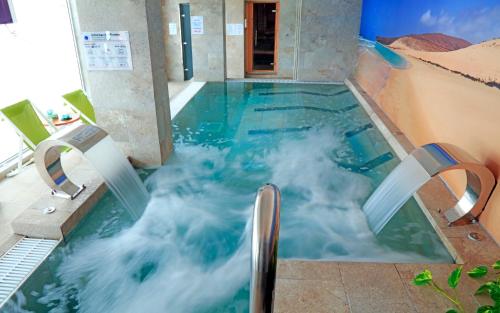 a swimming pool with a water slide in a building at FERGUS Cactus Garden in Playa Jandia