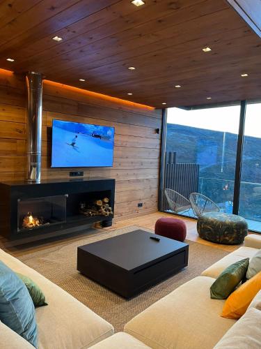 a living room with a fireplace and a tv at Lux 12 in Sierra Nevada