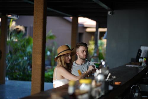 a man and woman sitting at a bar looking at their cell phone at Red Thread Morjim in Morjim