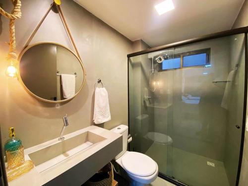 a bathroom with a toilet and a sink and a mirror at FM20 CABO BRANCO Stilo - By Almare Flats in João Pessoa