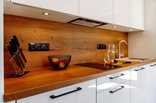 a kitchen with white cabinets and a wooden counter top at Apartamenty Belni Hel Edyta i Maciej Wolak in Hel