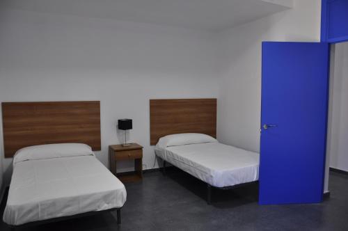 Cheles的住宿－Cruceros Alqueva，一间设有两张床和蓝色门的房间