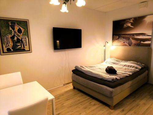 a bedroom with a bed and a flat screen tv at Pro Apartments 3 in Vaasa