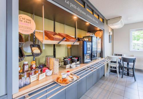 a bakery with a counter with food on it at B&B HOTEL Mulhouse Ile Napoléon in Illzach
