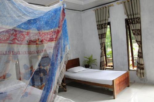 a bedroom with a bed and a mosquito net at Mountain View Cottages & Villa Tangkahan in Tangkahan
