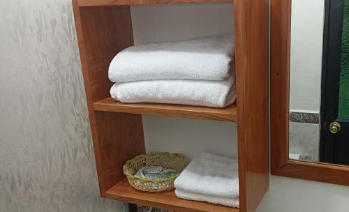 a pile of towels on a shelf in a bathroom at Teresita's House Suite 3 con cocina privada in Puerto Baquerizo Moreno