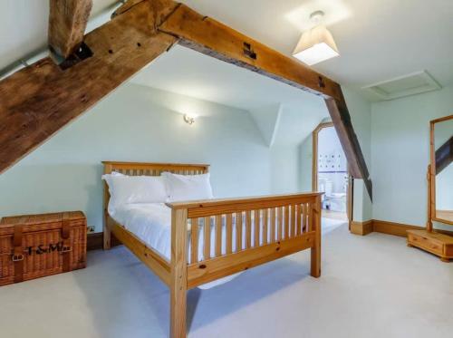 a bedroom with a wooden bed in a attic at Henrhiw Farm House at Henrhiw Farm Cottages in Usk