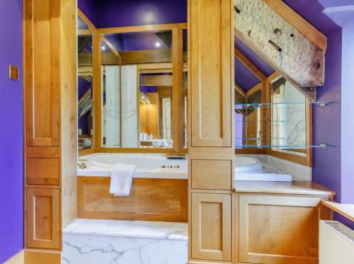 a bathroom with a large tub and a large mirror at Henrhiw Farm House at Henrhiw Farm Cottages in Usk