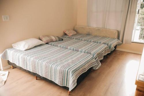 two beds in a small room with a bedskirts at Sitio Silveira Nobre - São Joaquim de Bicas in São Joaquim de Bicas